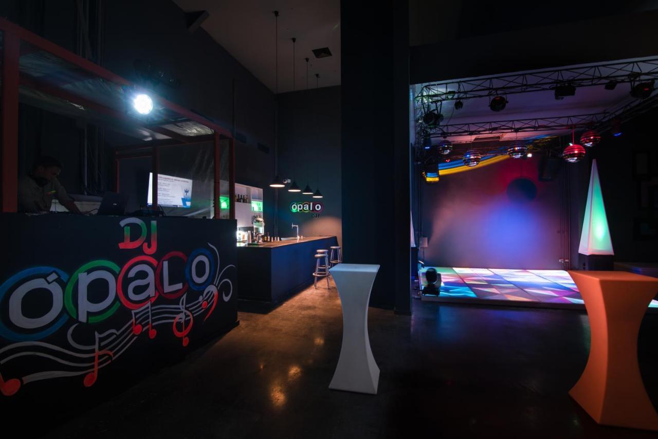 Impressive Punta Cana Esterno foto The photo shows the interior of a venue that appears to be a nightclub or party space. On the left side, there's a bar or DJ booth with the name "DJ Opalo" displayed prominently. The area features modern lighting and a dance floor with colorful light